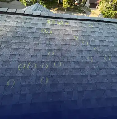 Hail impact points chalk-marked across an asphalt shingle roof during a storm damage inspection