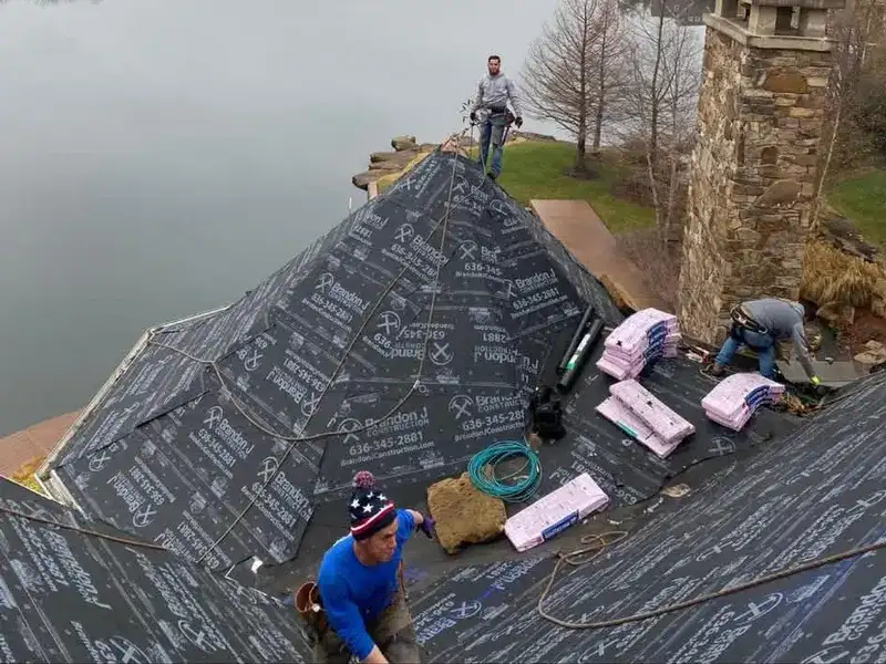 Brandon J Roofing crew installing underlayment on a lakeside home