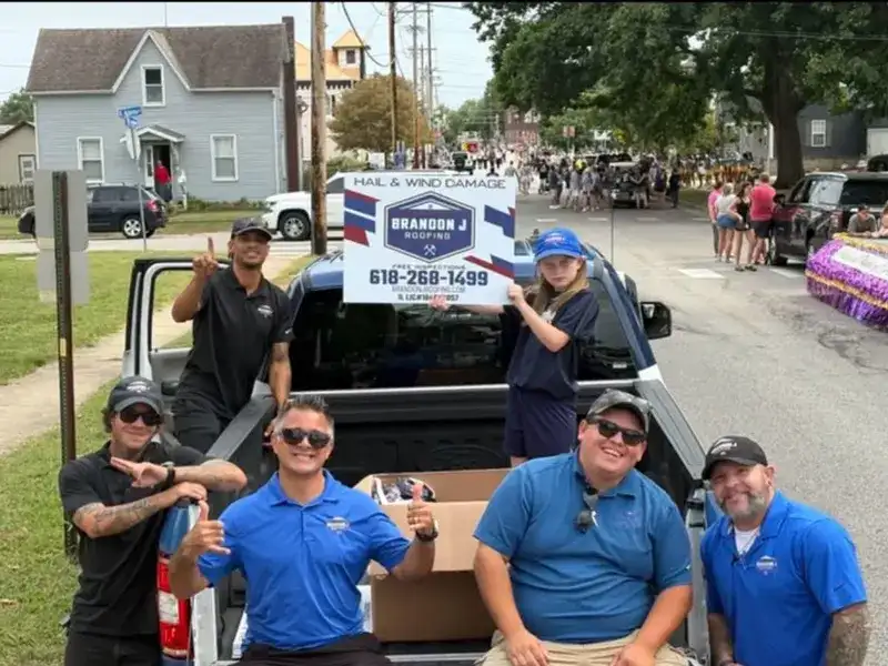 Nate Desemone and the Brandon J Roofing team with the company truck at a local community parade