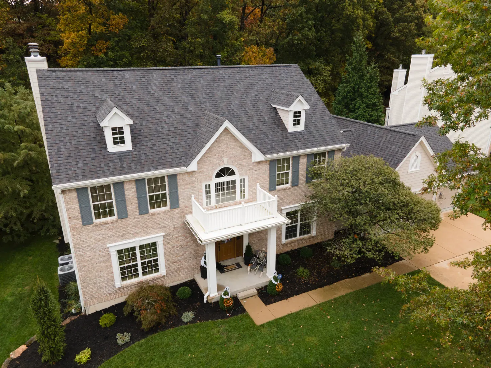 Two-story brick colonial home with a newly installed gray shingle roof