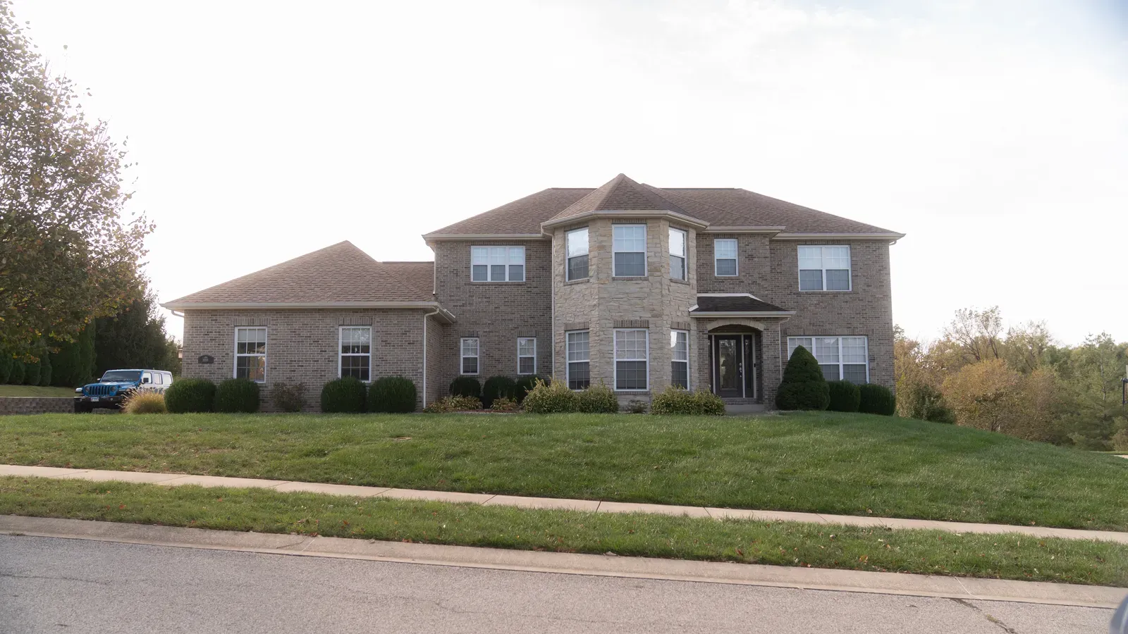 Two-story brick home with a completed shingle roof replacement