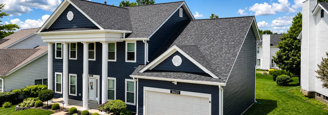 Aerial view of a navy two-story home in Chesterfield, Missouri with a newly installed charcoal architectural shingle roof.